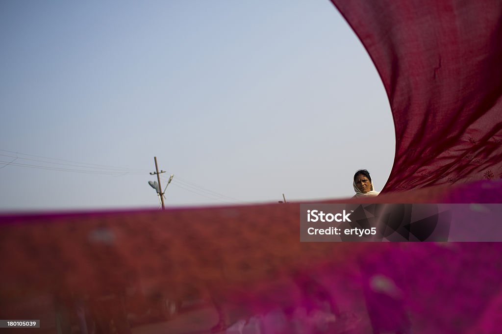 Hindu woman dries a sari on the river side Hindu woman dries a sari on the river side during the Kumbh Mela in Allahabad in IndiaHindu Sadhu Devotee looks on as a tourist takes his photo during the Kumbh Mela in Allahabad in India Prayagraj Stock Photo