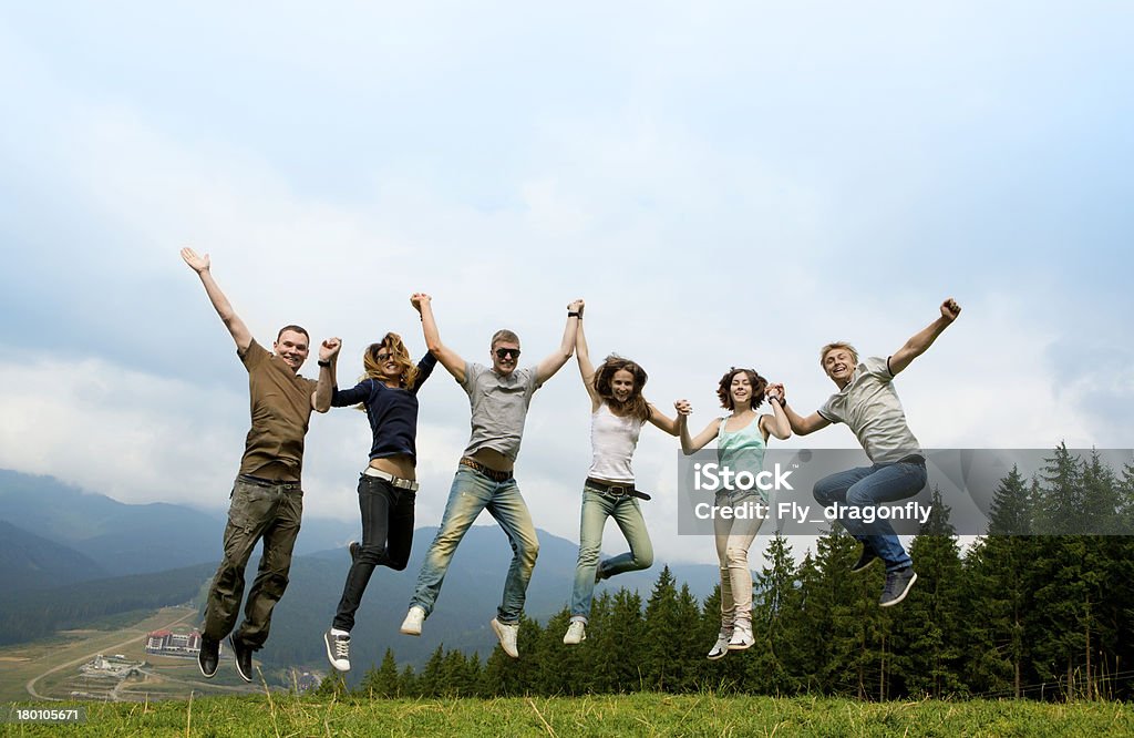 cheerful company of young friends People jumping and playing Outdoors on a background of mountain scenery western Ukraine, the Carpathians, Bukovel Group Of People Stock Photo