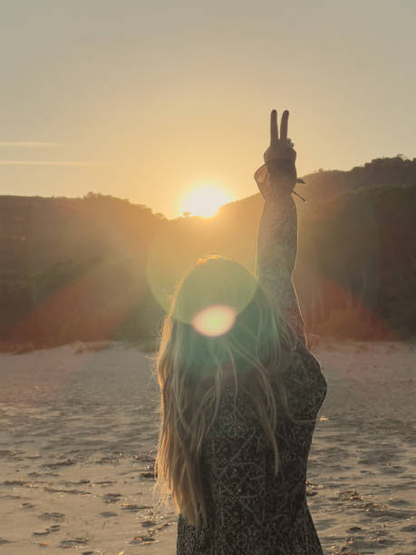 rear view of unrecognizable blonde woman bravely facing new goals and challenges. change and personal success by stepping out of the comfort zone and routine.vertical image with lens flare.copy space