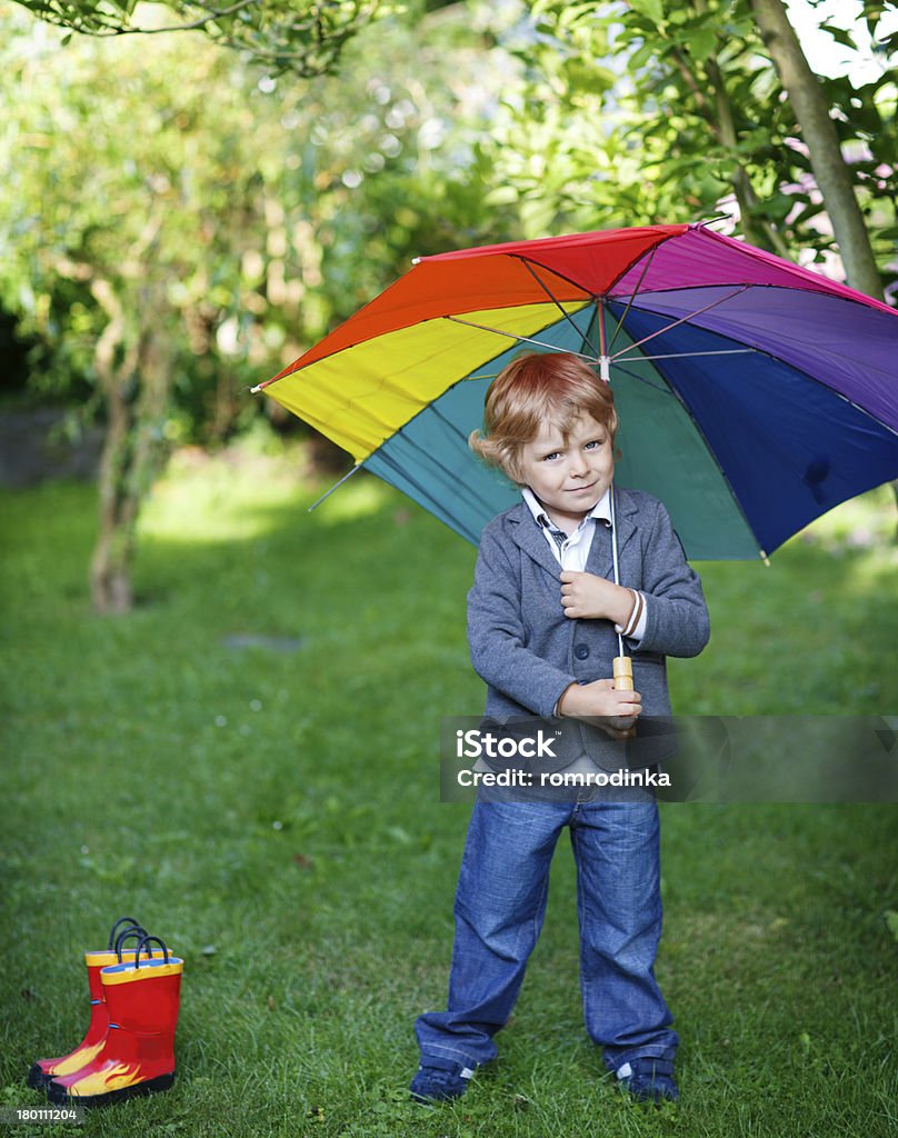 Poco carino piccolo ragazzo con ombrello colorato e stivali, outdoo - Foto stock royalty-free di 2-3 anni