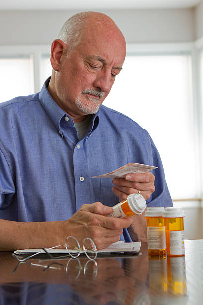 istock Older man reading information on prescription drugs 180111254