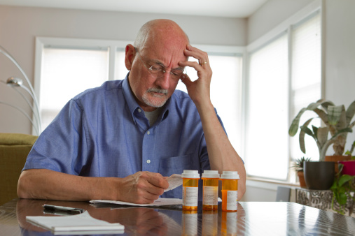 Older man with prescription bottles, horizontal