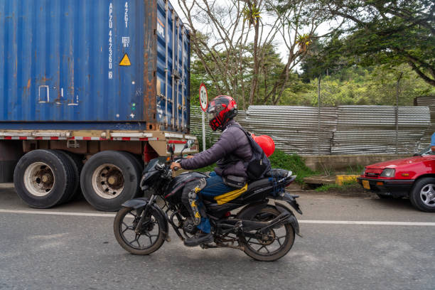 Motorcyclist in traffic on a Colombian country road.Valle del Cauca . Colombia. November 9, 2023.