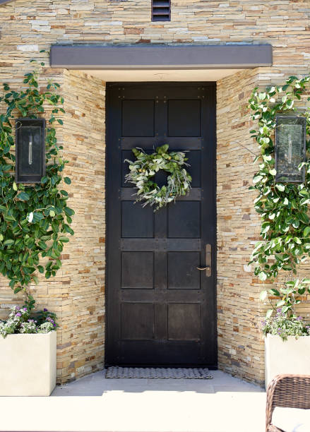istock Rustic wood panel door to a modern home with ledger stone 1801133314