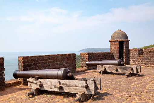 This image showcases the Reis Magos Fort, a historical landmark located along the banks of the Mandovi River in Goa. The fort, known for its distinctive red-laterite walls and rugged architecture, stands as a testament to Goa's rich colonial past. In the photograph, the fort's imposing structure is captured against the backdrop of the lush Goan landscape and the expansive river. The image aims to convey the historical significance of the Reis Magos Fort, highlighting its role as a defensive stronghold and a cultural heritage site. It offers viewers a glimpse into the architectural splendour and strategic importance of this well-preserved fort, making it a captivating subject for those interested in the history and architecture of Goa.