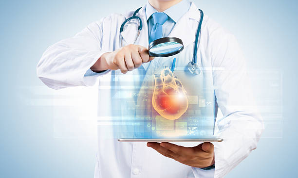 istock Doctor with tablet looking at heart hologram 180113816