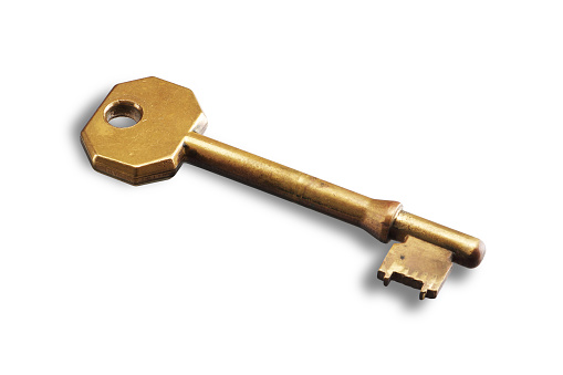 An old brass key on white background with shadow