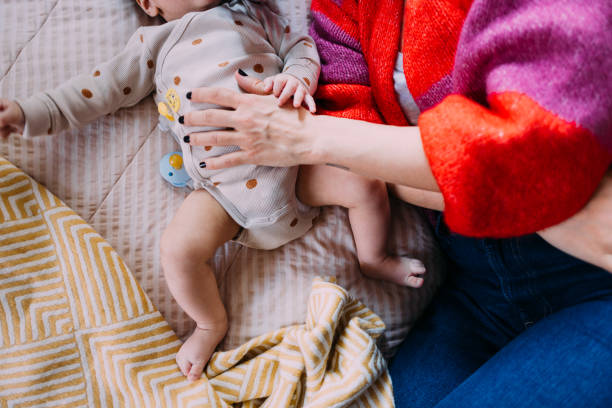 istock An Unrecognizable Mother Lying On The Bed With Her Unrecognizable Cute Baby Boy 1801168543