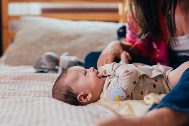 istock A Happy Beautiful Baby Boy Looking At His Unrecognizable Mother While Lying On The Bed 1801168661