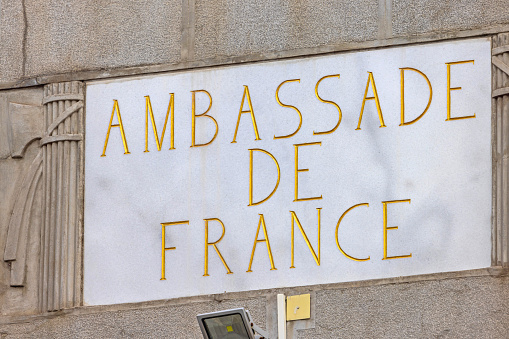 Belgrade, Serbia - September 23, 2023: Gold Letters Engraved in to White Marble Stone French Embassy Sign Ambassade de France Diplomatic Building.