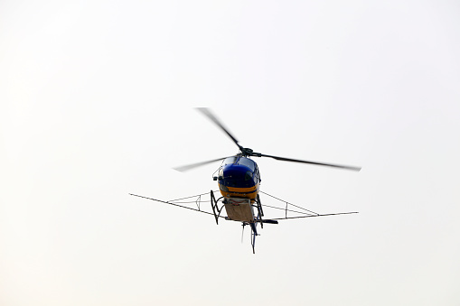 Autogiro flying against clear blue sky.