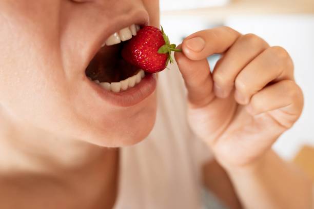 istock woman eats right and eats strawberries during snack 1801205851