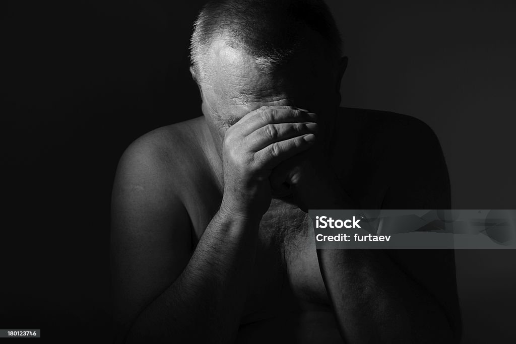 Triste uomo anziano con le mani sul viso su nero - Foto stock royalty-free di Sovrappeso