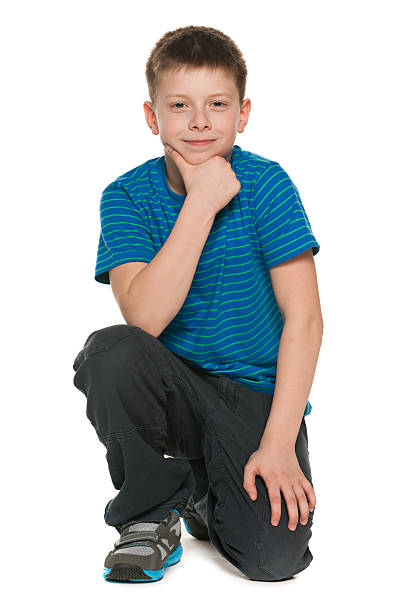 istock Pensive boy in blue shirt sits on the floor 180123895