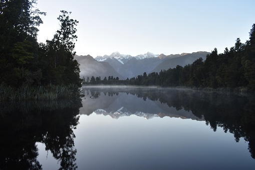 My cook and the southern alps reflecting on the lake while on a trip in south Westland