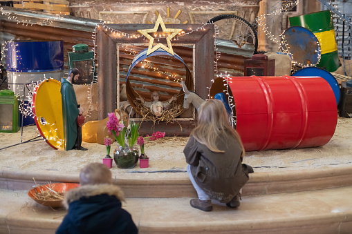 Children look at christmas creche with Joseph Mary and small Jesus