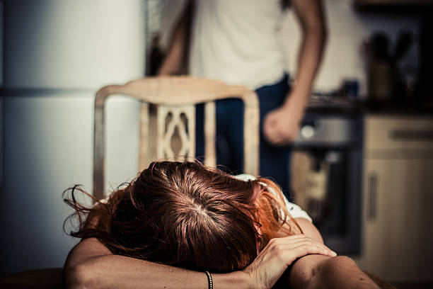 Young woman is victim of domestic abuse stock photo