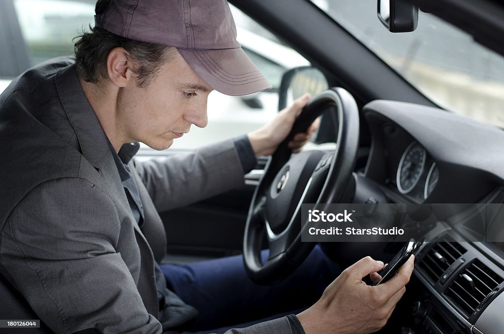 Человек в круг с помощью мобильного телефона во время вождения автомобиля - Стоковые фото Автомобиль роялти-фри