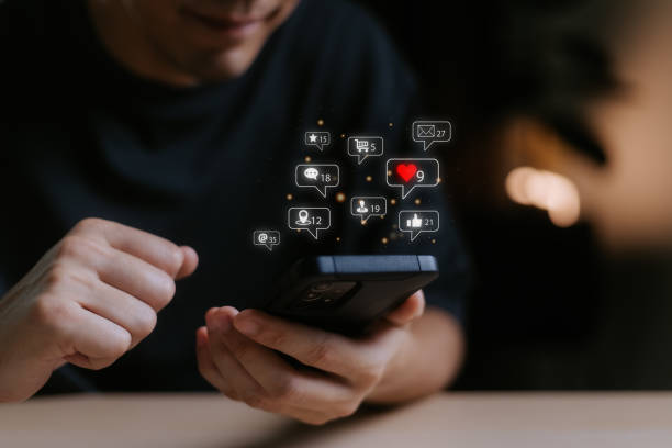 istock Man using smart phone with notification icons of love, like, message, comment, email, address, shopping and star above smartphone screen, Social, media, Marketing concept. 1801272563