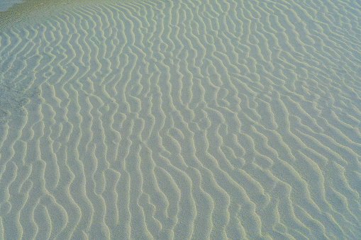Image captured of SAND formed and sculptured on the Farewell Spit which is a narrow sand spit at the northern end of the Golden Bay on the eastern side and the West Coast on the western side, in the South Island of New Zealand. The spit includes around 25 kilometres of stable land and another 5 kilometres of mobile sand spit running eastwards from Cape Farewell, the northern-most point of the South Island.