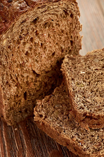 istock Slices of brown bread on a wooden table 180127593