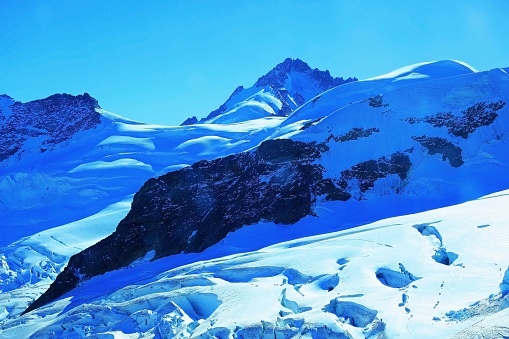 High mountains covered with snow under clear blue sky