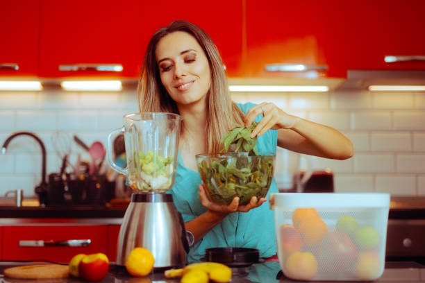 istock Smiling Woman Preparing a Green Smoothie in a Blender 1801316986