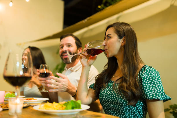 istock Hispanic woman drinking wine at dinner with her friends 1801322759