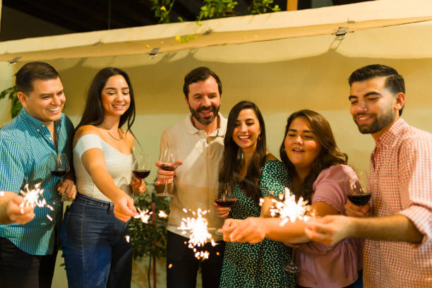 istock Group of hispanic friends celebrating with sparkles and drinking wine 1801351413