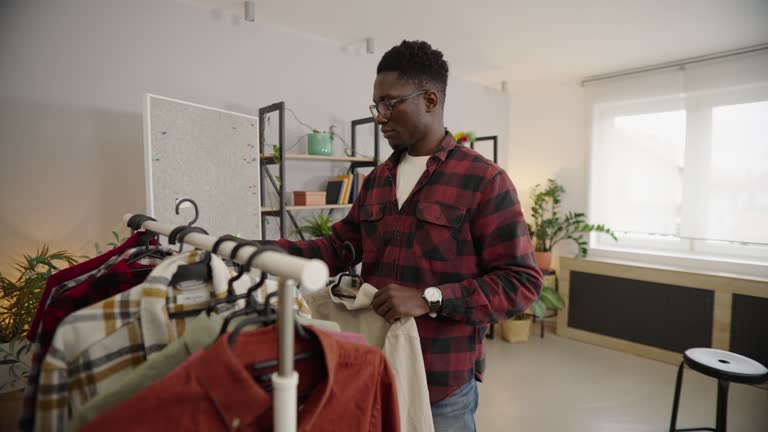 Man is choosing shirts to sell