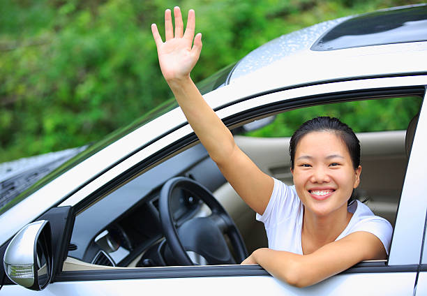 istock happy woman driver  wave hand give salute gesture 180154143