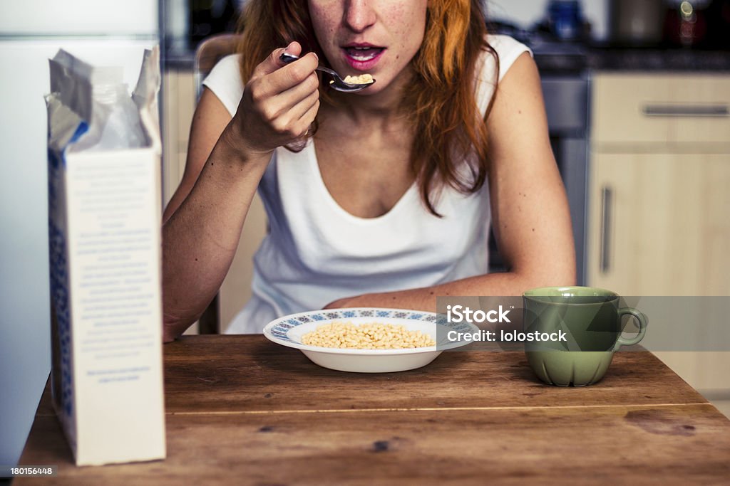 Jovem mulher tendo cereais para o café da manhã - Foto de stock de Caixa - Recipiente royalty-free