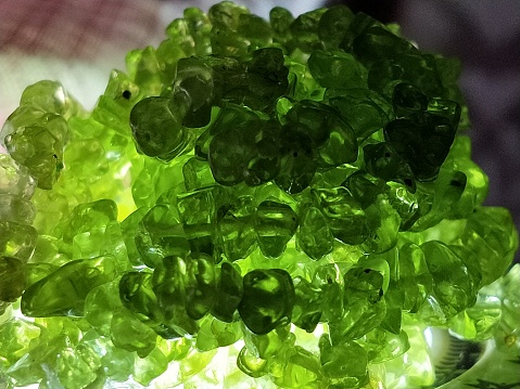 Greenish peridot gemstone beads captured in close-up view.