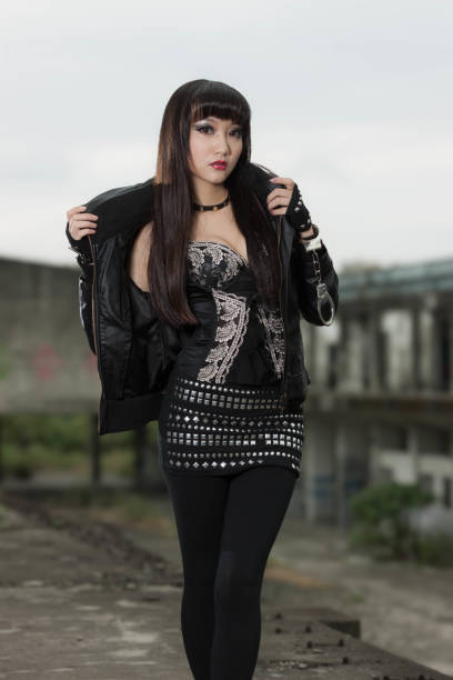 beautiful young tattooed woman with alternative style and dyed red hair in the street