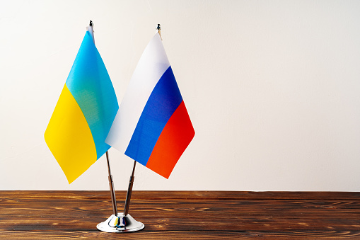 Small flags of Russia and Ukraine on flagpoles close up