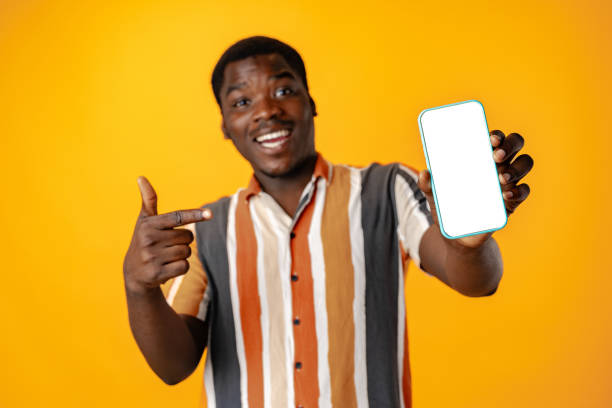 istock Young african man showing smartphone with isolated screen copy space 1801647720