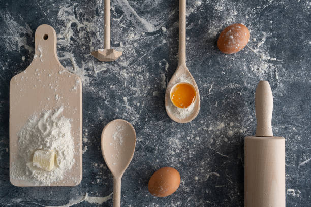 istock Baking flat lay composition on a flour-dusted table. Wooden kitchen utensils and dough ingredients. 1801652390