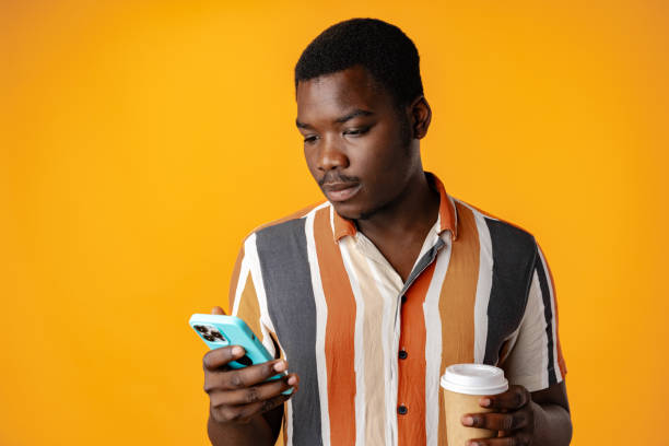 istock Young african man using smartphone againast yellow background 1801652912
