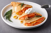 Pancakes with salmon, sour cream and greenstuff. Thin, not sweet blinchiki stuffed with red fish. Feast of Maslenitsa