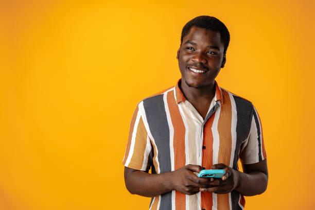 istock Young african man using smartphone againast yellow background 1801662818