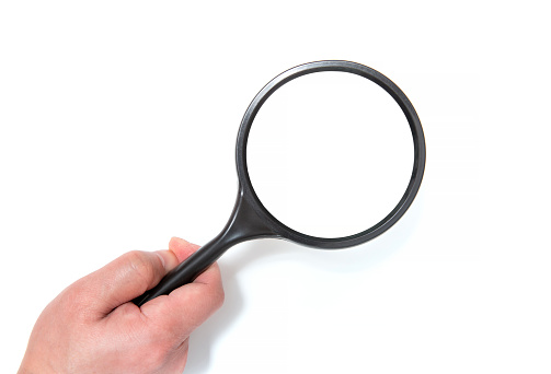 Holding magnidying glass  isolated on background. Detective and search Concept.