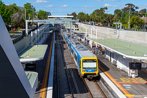 Melbourne, Australia - Nov 4, 2023: Melbourne's new Union Station looking north to Box Hill with a PTV-MTM (Metro Trains Melbourne) train in platform 2.\nVictoria’s Big Build has removed 2 of Melbourne’s most dangerous and congested level crossings at Union Road, Surrey Hills and Mont Albert Road, Mont Albert and built a brand-new Union Station.\nEarly works started in June 2021, the level crossings were removed in May 2023 and the fast-tracked station opened on Monday 22 May with trains running on the Belgrave and Lilydale lines in the new 1.3km rail trench beneath Mont Albert and Union roads. \nThe works will ease congestion and make driving safer as the crossing boom gates at these sites were down for up to 40% of the morning peak, when up to 61 trains ran through the crossings.