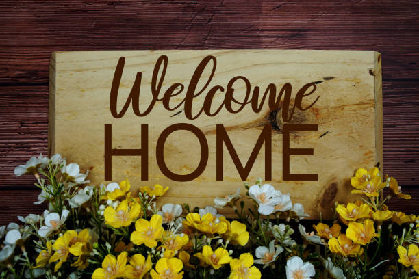 istock Welcome Home text message with flower decoration on wooden background 1801704951