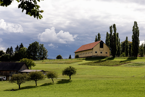 An old large stable on a hill against a stormy sky
