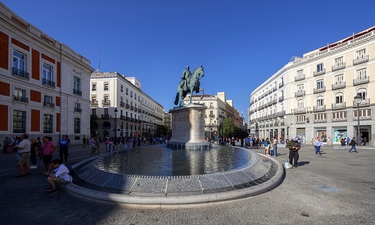 Madrid, Spain, October 6, 2023: View of the town square Puerta del Sol with the statue of the king Carlos III in the downtown of Madrid on a sunny autumn day.