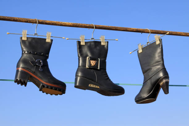 women's boots hanging in the blue sky, closeup of photo