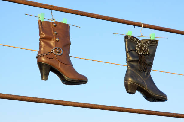 women's boots hanging in the blue sky, closeup of photo