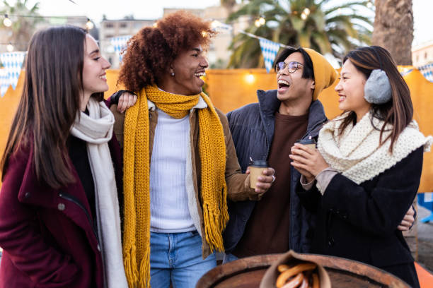 junge gruppe von menschen, die im winter gemeinsam spaß auf dem weihnachtsmarkt haben - people group of people friendship salzburg stock-fotos und bilder