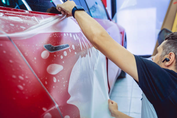 istock The process of installing protective film on the new red car. 1801775015