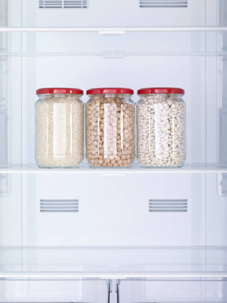 istock Rice, chickpeas and beans in three separate jars on the empty refrigerator shelf. No people. 1801786083